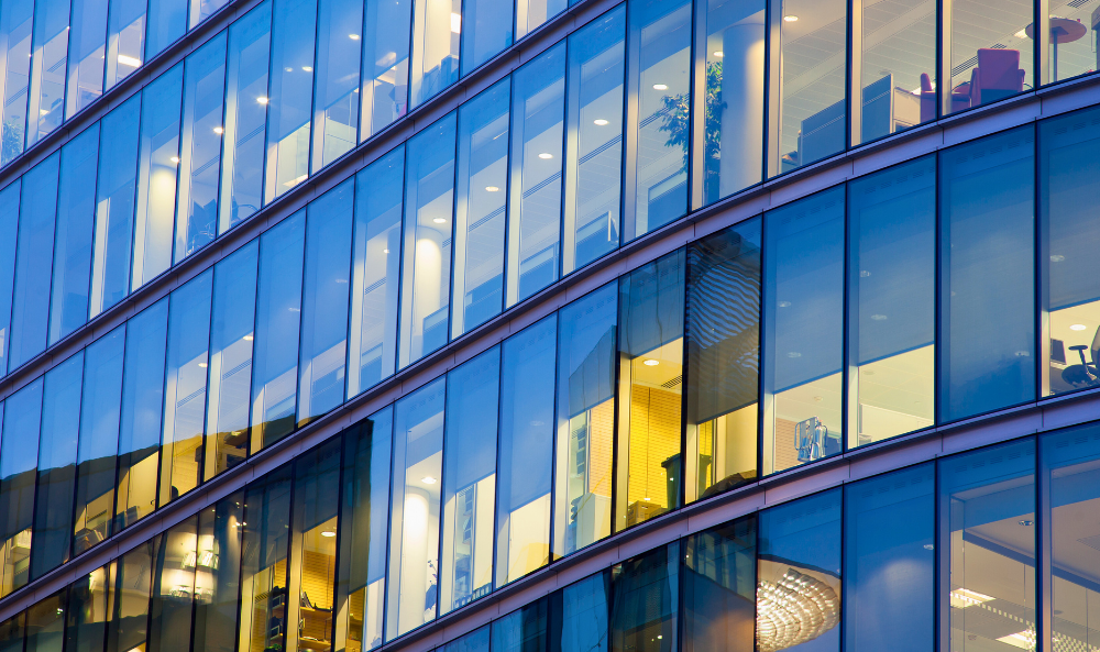 Commercial Agency Image - glass office windows in high rise building with yellow ambient light coming through