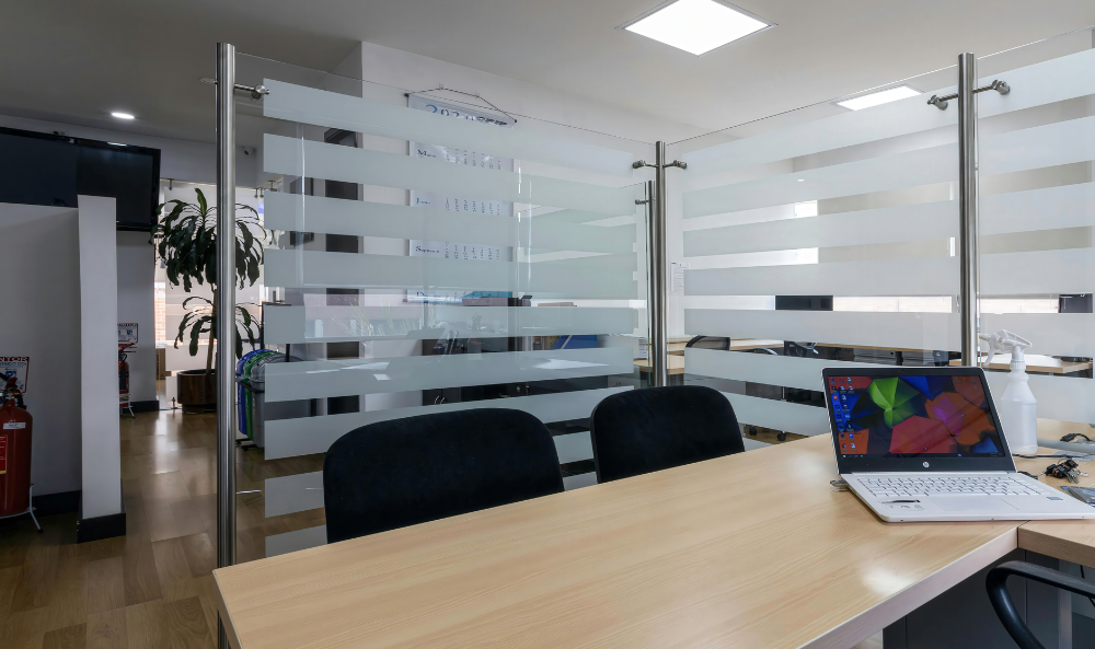 Commercial Property Management Page image of a modern office desk with a wooden top and a laptop at the side of the desk