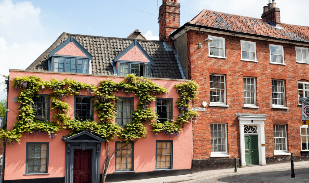 Landlord Page - pink building next to a brick building an a road in Norfolk