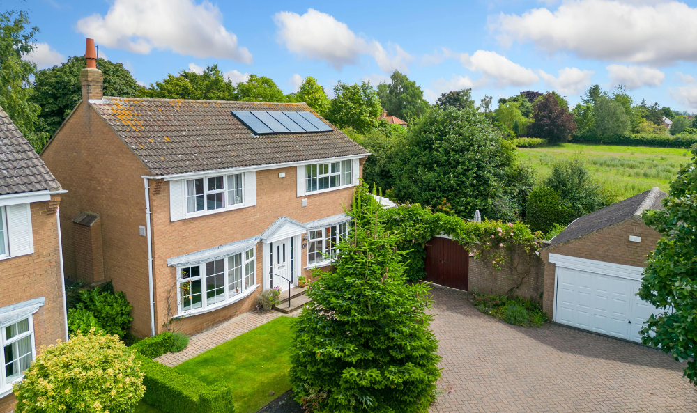 How Sellers Can Reassure Buyers on Affordability in Today’s Norfolk Property Market image - large house in Norfolk next to fields at the edge of a street